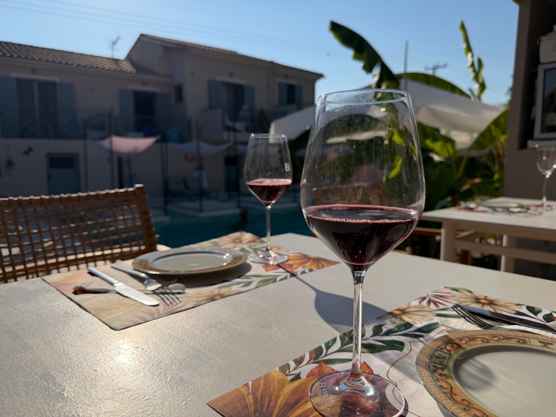 Two glasses of red wine poolside